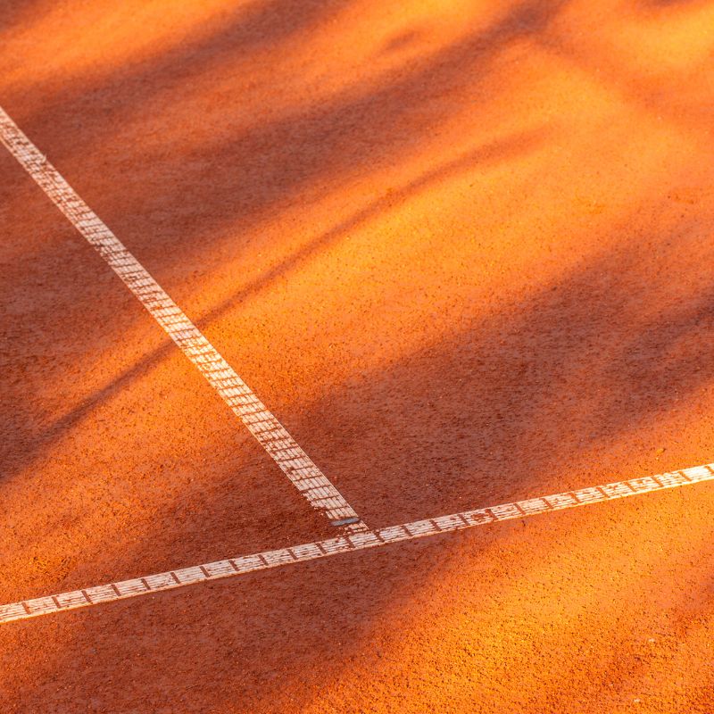 sundby-tennis-aktiviteter Rød grusbane i aftenlys